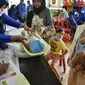 Seorang balita ditimbang badannya sebelum menerima vaksin campak dan polio di sebuah posyandu di Banda Aceh, Aceh, Rabu (4/10/2020). Pemberian vaksin polio dan vaksin campak secara gratis yang berlanjut di tengah pandemi COVID-19 bertujuan memperkuat imunitas anak. (CHAIDEER MAHYUDDIN / AFP)