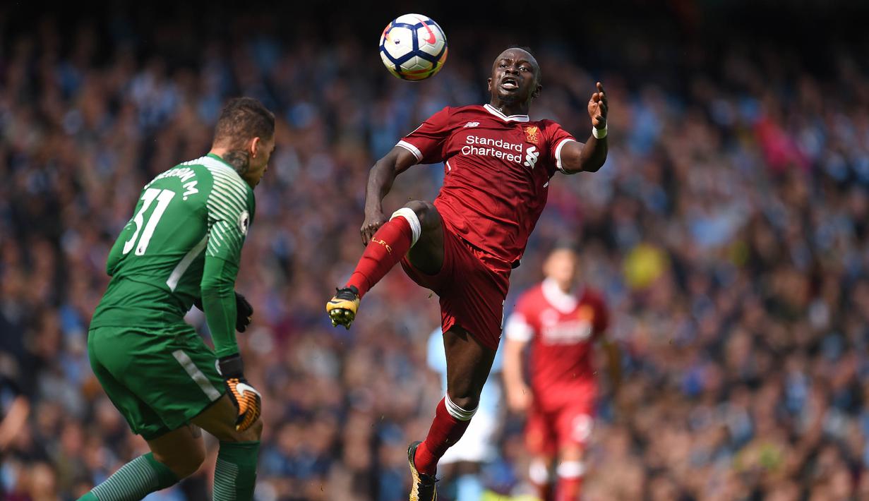Penyerang Liverpool, Sadio Mane, berebut bola dengan kiper Manchester City, Ederson Moraes, pada laga Premier League di Stadion Ettihad, Manchester, Sabtu (9/9/2017). Akibat insiden ini Ederson mengalami luka parah. (AFP/Oli Scarff) 