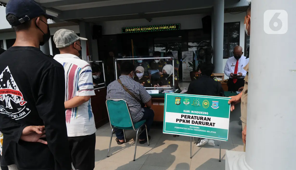 Pelanggar membayar denda saat Sidang Tipiring PPKM Darurat di kantor Kecamatan Pamulang, Tangerang Selatan, Banten, Senin (19/7/2021). Dua puluh empat pelanggar PPKM Darurat diantaranya tidak bermasker dan jam operasional tempat usaha didenda Rp 100 ribu hingga Rp 500 ribu. (merdeka.com/Arie Basuki)