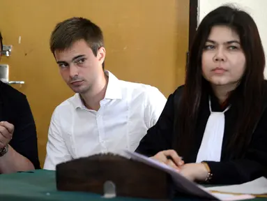 Antony Lambert berbincang dengan kuasa hukumnya saat menjalani persidangan di pengadilan Denpasar, Bali, Indonesia (14/9). Pria 23 tahun ini ditangkap saat tiba di Bali dari Kuala Lumpur pada bulan Juni. (AFP Photo/Sony Tumbelaka) 