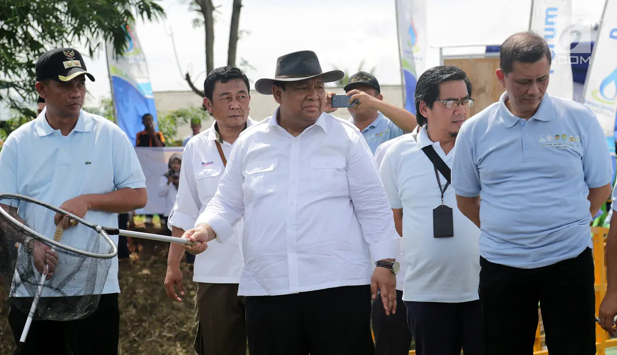 Dirut Perum Jasa Tirta II, Djoko Saputro (tengah) saat menebar benih dan panen ikan bandeng di demplot Curug, Jatiluhur, Kamis (6/12). Kegiatan yang digelar Perum Jasa Tirta II melibatkan petani lokal dengan program CBF. (Liputan6.com/Pool/HumasPJT2)