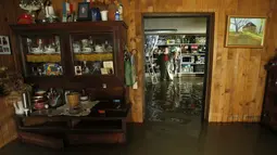 Salah satu warga desa Zazina, Kroasia, berada di dalam rumahnya yang terendam air pasca hujan deras yang turun sejak Rabu lalu, (15/9/2014). (REUTERS/Antonio Bronic)