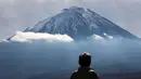 Seorang turis melihat Gunung Fuji dari Fujikawaguchiko, Prefektur Yamanashi, Jepang (1/11). Gunung Fuji adalah gunung tertinggi di Jepang, terletak di perbatasan Prefektur Shizuoka dan Yamanashi, di sebelah barat Tokyo. (AFP Photo/Behrouz Mehri)