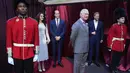 Pria berpakaian pengawal kerajaan berdiri mengawasi patung lilin Raja Charles III, Pangeran William dan Princess of Wales, Kate Middleton serta Pangeran Harry di halaman depan Queen Victoria Building di Sydney, Australia, Rabu (3/5/2023). (AP Photo/Rick Rycroft)