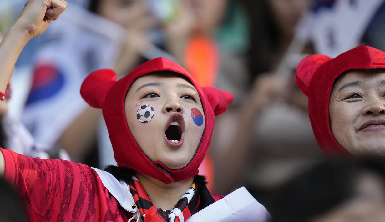 Para suporter wanita ini tampak semangat mendukung Korea Selatan dalam laga yang dilangsungkan pada sore hari waktu Qatar. (AP Photo/Alessandra Tarantino)
