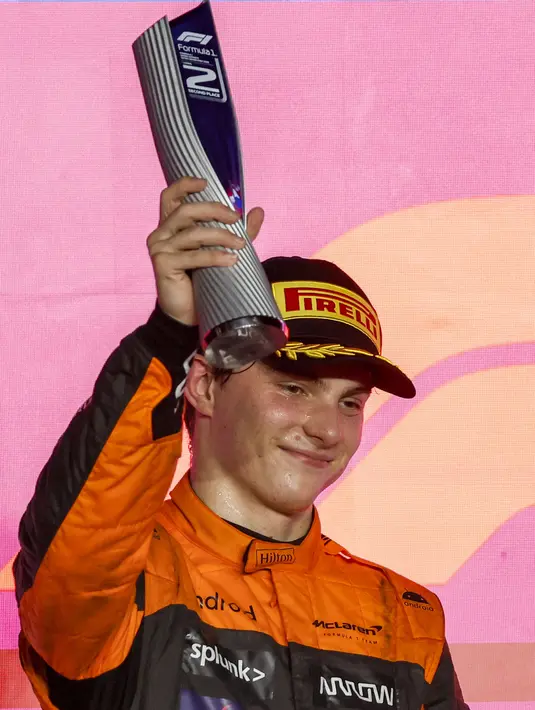 Pembalap McLaren, Oscar Piastri mengangkat trofi di atas podium setelah finis kedua pada ajang balap Formula 1 GP Qatar 2023 yang berlangsung di Sirkuit Lusail, Qatar, Minggu (08/10/2023) malam WIB. Ini merupakan podium kedua Piastri setelah F1 GP Jepang 2023. (AFP/Karim Jaafar)