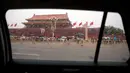 Foto mantan pemimpin Cina Mao Zedong terlihat melalui jendela mobil di Gerbang Tiananmen di sebelah Lapangan Tiananmen di Beijing (4/6/2019). Pemerintah China meningkatkan keamanan di sekitar Lapangan Tiananmen di pusat Beijing jelang peringatan tragedi Tiananmen 1989. (AP Photo/Mark Schiefelbein)