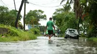 Penduduk mengarungi jalan-jalan yang banjir di ibu kota Fiji Suva pada 16 Desember 2020, menjelang topan super Yasa. (Foto: AFP / Leon Lord)
