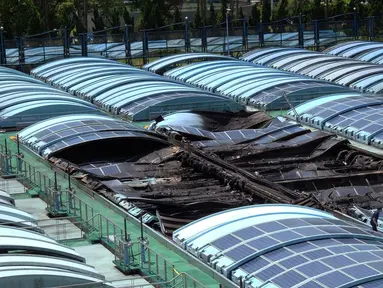 Peneliti mengecek panel surya di sebuah taman air yang terbakar saat gelombang panas melanda Taipei, Taiwan, (28/7). Lebih dari 1.200 orang dievakuasi akibat kejadian yang diakibatkan oleh korsleting listrik. (AFP PHOTO/SAM YEH)
