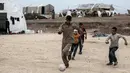 Seorang anak berusaha mengiring bola saat bermain sepak bola di sebuah kamp di al-Bil, timur dari kota Azas yang dikuasai pemberontak di Suriah utara (21/4). (AFP Photo/Sameer Al-Doumy)