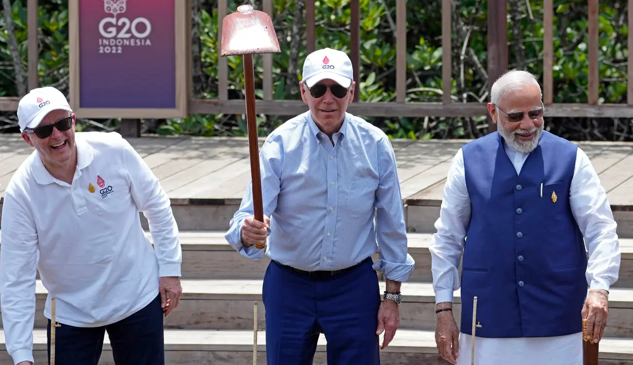 Presiden AS Joe Biden (tengah) bersama Perdana Menteri Australia Anthony Albanese (kiri) dan Perdana Menteri India Narendra Modi (kanan) mengangkat cangkul saat acara penanaman pohon mangrove di sela-sela pertemuan KTT G20 di Taman Hutan Raya Ngurah Rai, Denpasar, Bali, Indonesia, Rabu (16/11/2022). (AP Photo/Alex Brandon, Pool)