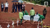 Petugas memakamkan jenazah dengan protokol COVID-19 di TPU Pondok Ranggon, Jakarta, Sabtu (7/11/2020). Pemakaman jenazah dengan protokol COVID-19 dalam sepekan mengalami penurunan, untuk hari ini ada sekitar 20 orang yang datang silih berganti (merdeka.com/Imam Buhori)