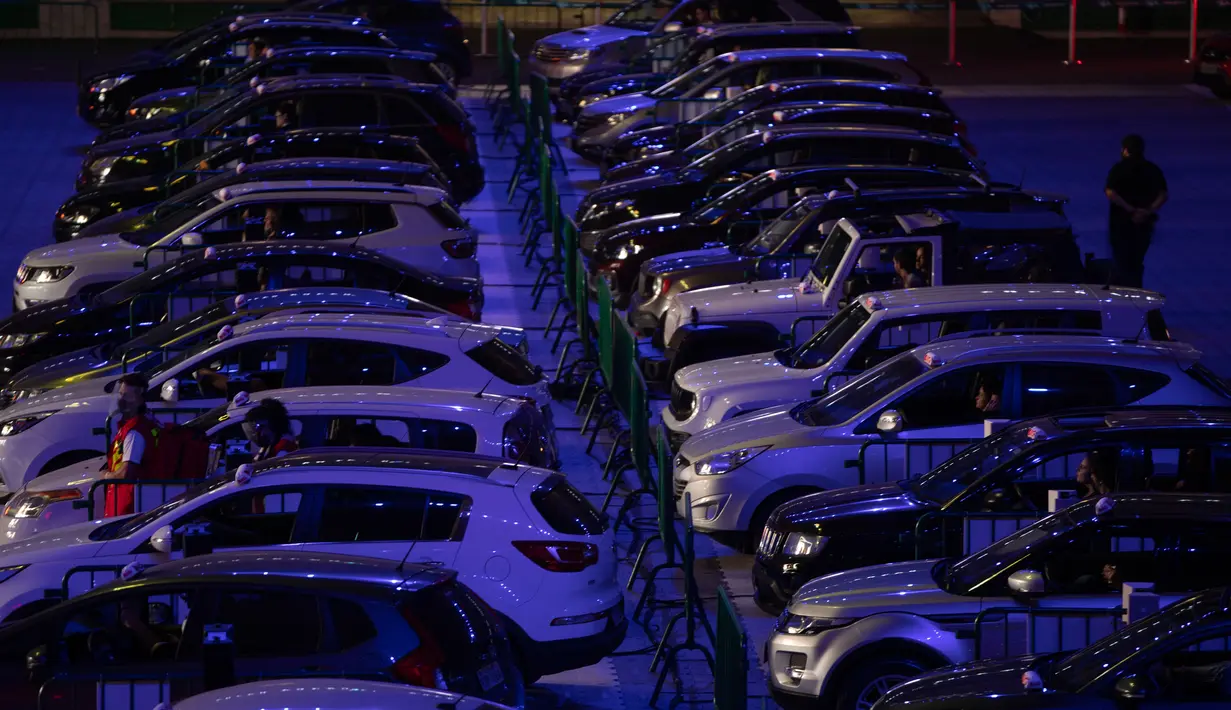 Orang-orang menonton film dari dalam mobil mereka di drive in yang dipasang di stadion sepak bola Palmeiras di Sao Paulo, Brasil, Kamis (25/6/2020). Stadion yang dapat menampung hingga 300 mobil tersebut berubah fungsi menjadi lokasi bioskop drive ini di masa pademi Covid-19. (AP Photo/Andre Penner)