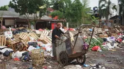 Petugas kebersihan berada di sekitar Jalan Masjid Al Makmur, Pejaten Timur, Pasar Minggu, Jakarta Selatan, Selasa (10/12/2019). Tumpukan sampah yang tidak hanya berasal dari warga sekitar menimbulkan bau tidak sedap dan dikhawatirkan dapat mengganggu kesehatan. (Liputan6.com/Immanuel Antonius)