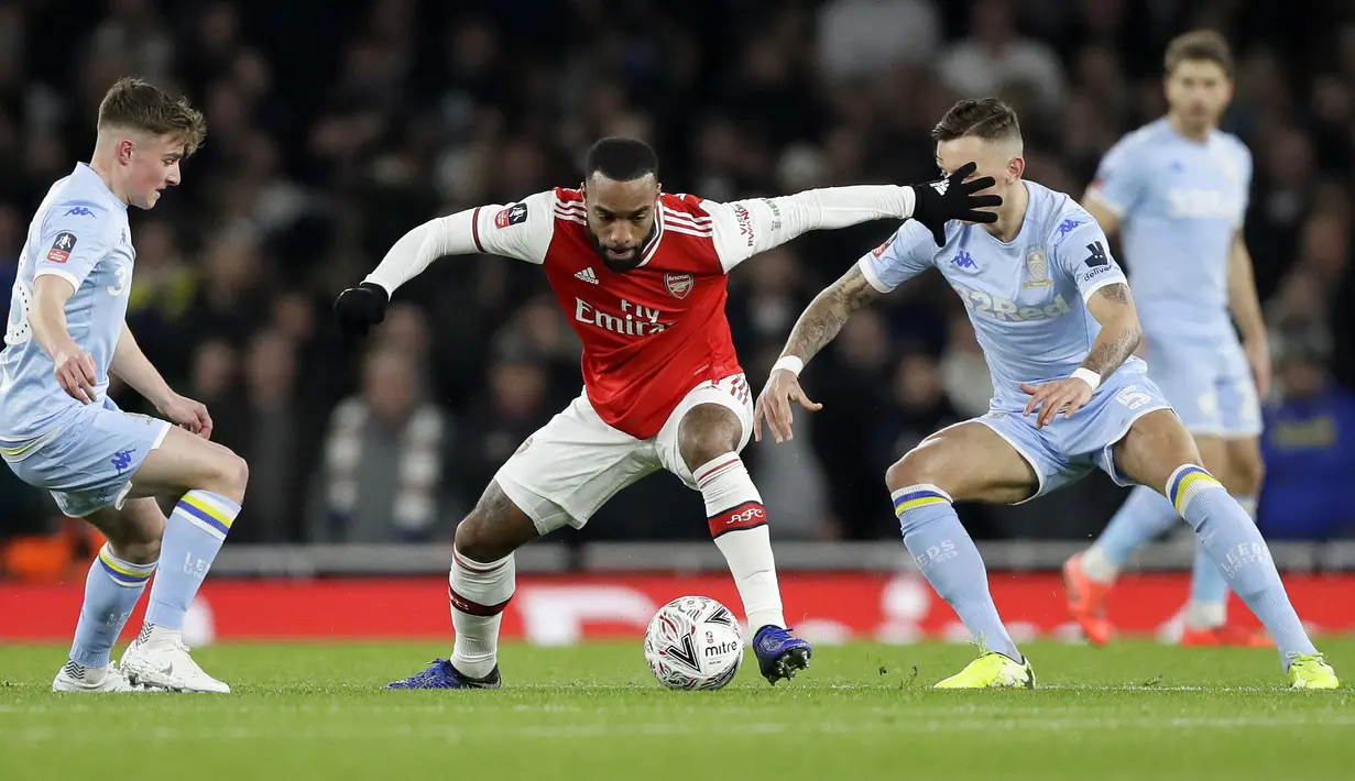 Penyerang Arsenal, Alexandre Lacazette membawa bola dari kawalan dua pemain Leeds United pada pertandingan Piala FA di Emirates Stadium, Inggris (6/1/2019). Arsenal menang tipis 1-0 atas Leeds. (AP Photo/Kirsty Wigglesworth)