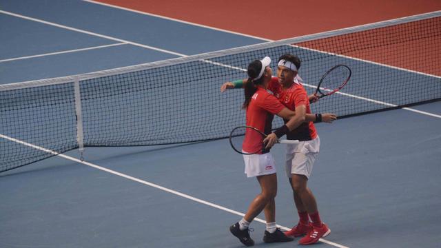 Aldilla Sutjiadi - Christoper Benjamin Rungkat berpelukan usai memenangkan pertandingan semifinal Asian Games (Liputan6.com / Nefri Inge)