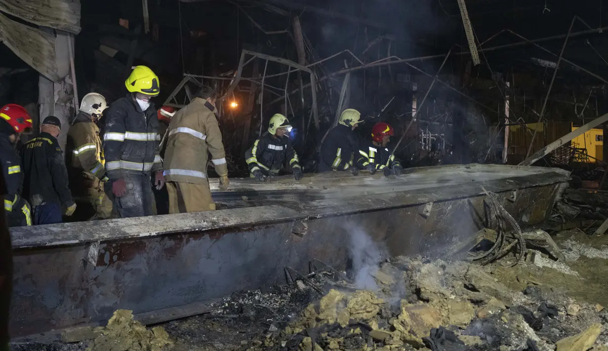 Petugas pemadam kebakaran Layanan Darurat Negara Ukraina bekerja untuk memadamkan api di pusat perbelanjaan yang terbakar setelah serangan roket di Kremenchuk, Ukraina, Senin malam (27/6/2022) malam. (AP Photo/Efrem Lukatsky)