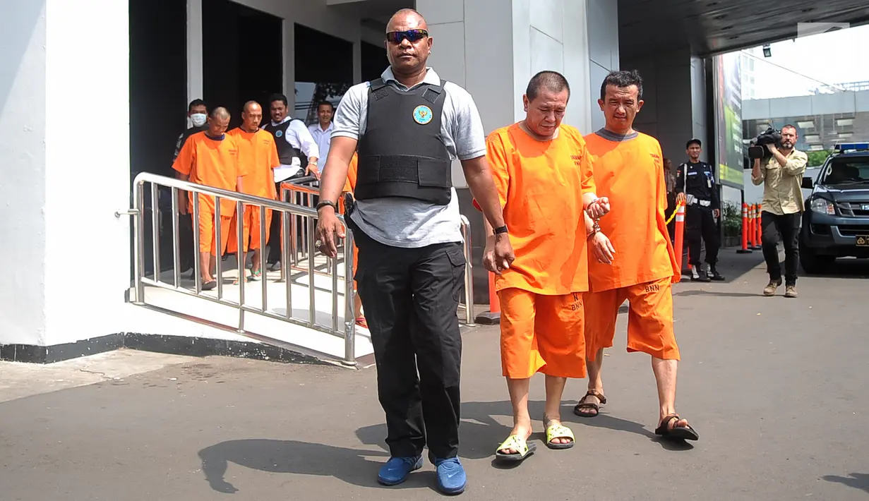 Petugas membawa bandar narkotika jenis sabu, Togiman alias Toge, setelah merilis jaringan narkotika internasional di Kantor BNN, Jakarta, Senin (22/5). BNN mengamankan 25 kg sabu yang dikendalikan dari Lapas Tanjung Gusta. (Liputan6.com/Yoppy Renato)