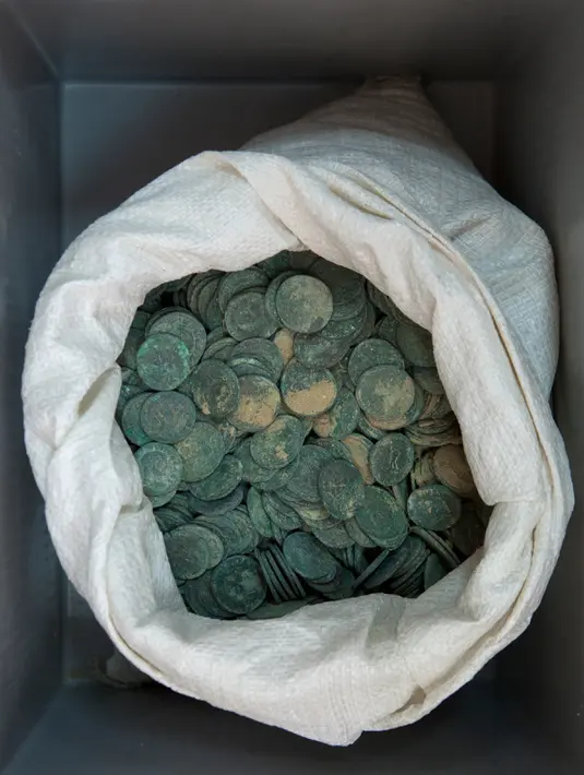 Sekantong koin kuno Romawi yang disimpan di museum arkeologi di Sevilla, Kamis (28/4). Koin-koin yang berasal dari abad III dan awal abad IV itu ditemukan berada di dalam 19 amphora (semacam kendi) Roma yang berlokasi di Kota Tomares. (Gogo Lobato/AFP)