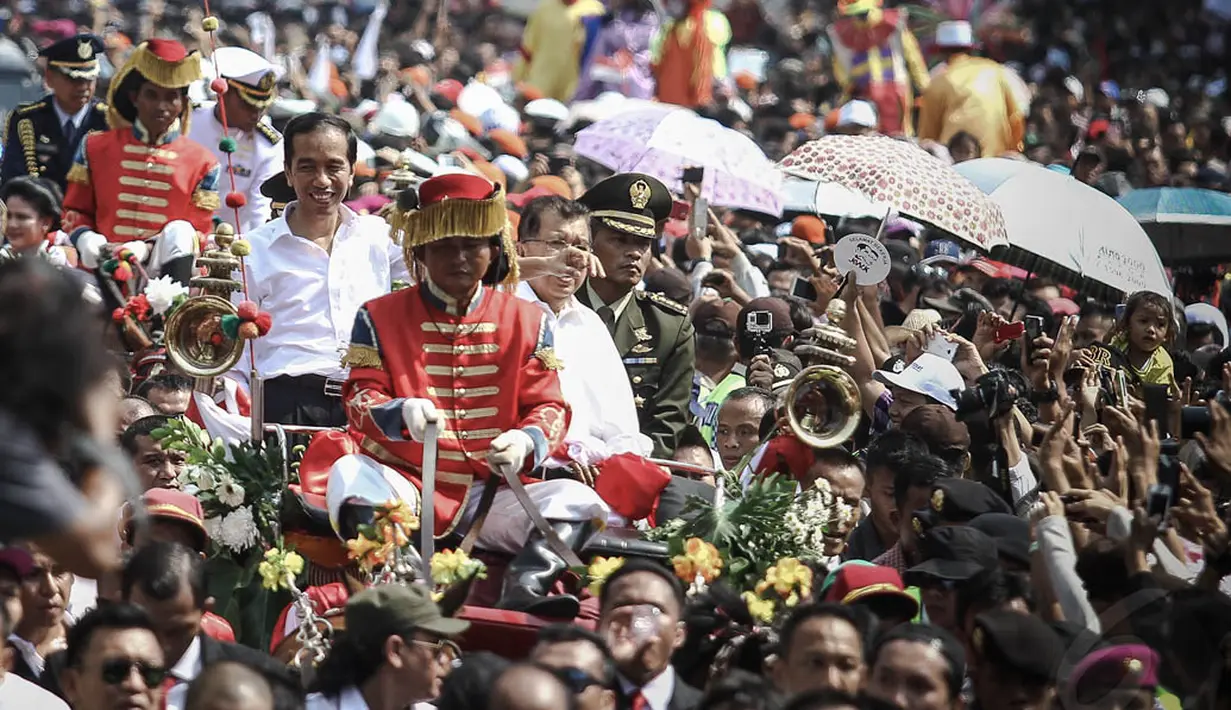 Di atas kereta kuda, Jokowi-JK membuka jas dan dasi serta menggulung kemeja lengan panjang yang dikenakan saat pelantikan, Jakarta, (20/10/14). (Liputan6.com/Faizal Fanani) 