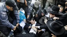 Pasukan keamanan Israel berusaha membubarkan demonstran di Yerusalem (17/10). Protes tersebut menimbulkan ketegangan antara warga dengan pemerintah. (AFP Photo/Menahem Kahana)