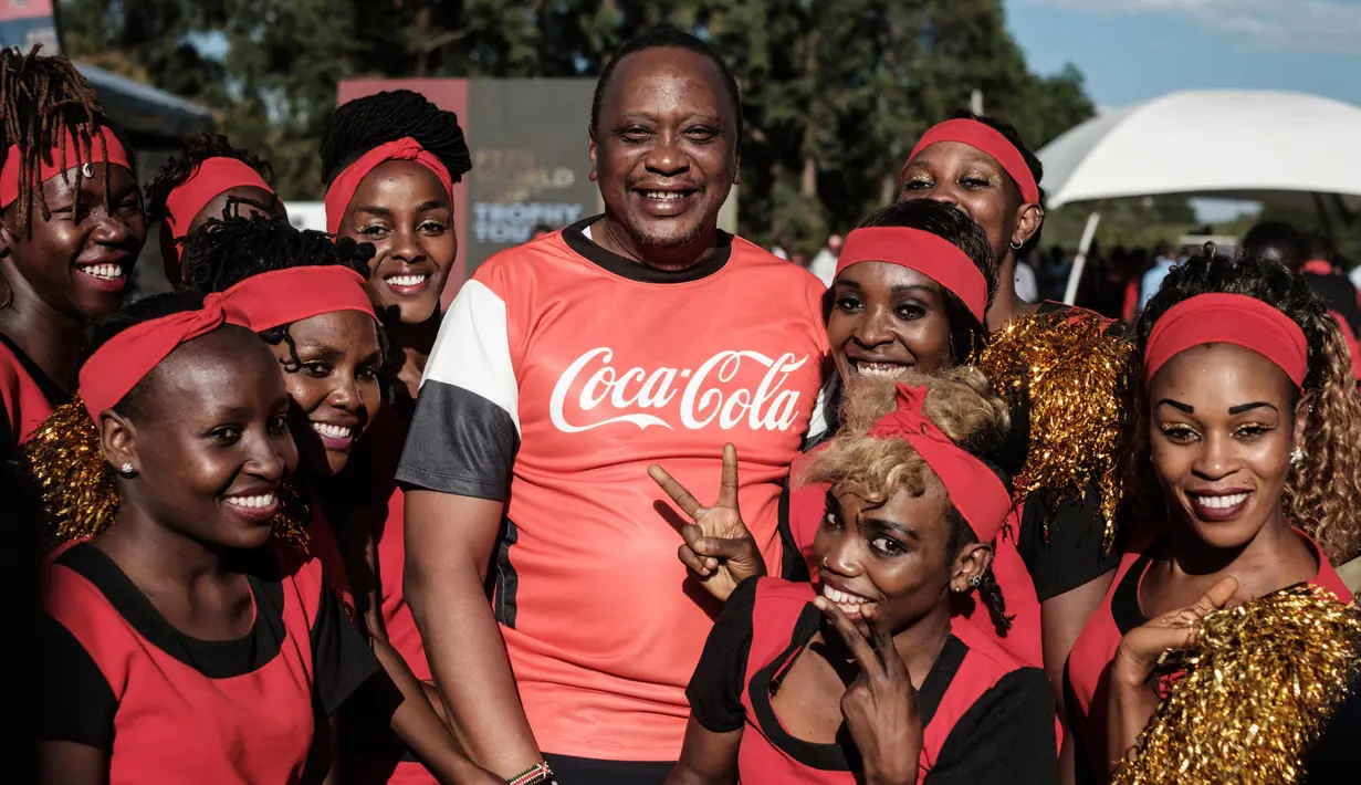 Presiden Kenya Uhuru Kenyatta foto bersama dengan warga selama tur trofi Piala Dunia FIFA Tour di State House di Nairobi (26/2). (AFP Photo/Yasuyoshi Chiba)