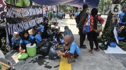 Warga gusuran Kampung Bayam saat menggelar aksi di depan Balai Kota DKI Jakarta, Kamis (1/12/2022). Dengan membawa terpal dan perabotan rumah tangga, puluhan korban gusuran Kampung Bayam mendatangi Balai Kota untuk menuntut PT Jakarta Propertindo (JakPro) segera menyerahkan kunci hunian Kampung Susun Bayam (KSB) serta memberikan harga sewa yang murah. (merdeka.com/Iqbal S Nugroho)