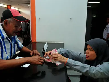 Warga menerima dana Program Simpanan Keluarga Sejahtera (PSKS) di Kantor Pos Rawamangun, Jakarta, Rabu (19/11/2014). (Liputan6.com/Johan Tallo)