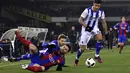 Bintang FC Barcelona, Lionel Messi terjatuh saat dihadang dua pemain Real Sociedad pada laga prempat final Copa Del Rey di Anoeta stadium, San Sebastian,  Kamis (19/1/2017). Barcelona menang tipis 1-0.  (AP/Alvaro Barrientos)