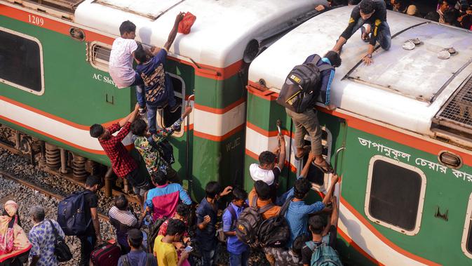 Ratusan orang berupaya menaiki atap kereta api untuk menuju kampung halaman di Dhaka, Bangladesh pada 4 Juni 2019. Pemadangan mencengangkan dari ratusan yang naik dan duduk di atas kereta karena gerbong yang penuh terlihat pada menjelang Idul Fitri di Bangladesh. (MUNIR UZ ZAMAN/AFP)