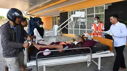 Seorang anak korban gempa Lombok mendapat perawatan medis di luar Rumah sakit Moh. Ruslan di Mataram,  Senin (6/8). Berdasarkan laporan sementara yang diterima BPBD NTB, korban meninggal akibat gempa Lombok sudah mencapai 89 orang. (AFP/ADEK BERRY)
