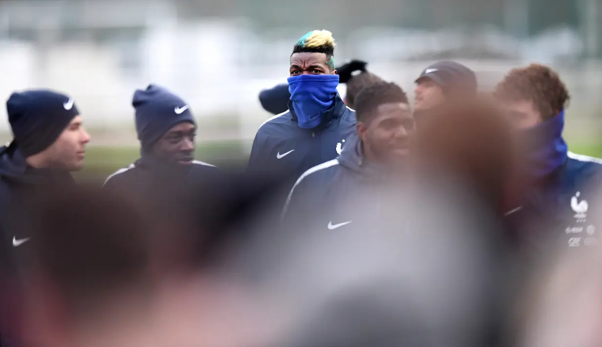Gelandang timnas Prancis Paul Pogba bersama rekan setimnya bersiap mengikuti sesi latihan di Clairefontaine-en-Yvelines, Paris (19/3). Prancis bersiap melakukan pertandingan melawan Kolombia dan Rusia. (AFP Photo/Franck Fife)