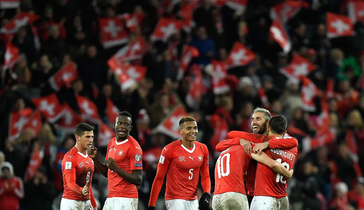 Pemain timnas Swiss merayakan kemenangan atas Irlandia Utara  seusai leg kedua fase playoff Piala Dunia 2018 zona Eropa di St Jakob Park Stadium, Minggu (12/11). Swiss akhirnya lolos ke Piala Dunia 2018. (Jean-Christophe Bott/Keystone via AP)