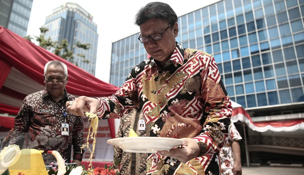 Mendagri Tjahjo Kumolo mengambil nasi tumpeng pada peresmian Kantor Badan Nasional Pengelola Perbatasan (BNPP) di Jakarta, (19/5). BNPP merupakan lembaga yang bertanggung jawab mengkordinasikan pengelolaan perbatasan negara. (Liputan6.com/Faizal Fanani)
