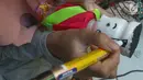 Perajin menyelesaikan pembuatan miniatur ondel-ondel di rumah produksi Kramat Jati, Jakarta, Senin (23/6/2019). Miniatur ondel-ondel yang terbuat dari limbah botol plastik itu dibuat sesuai dengan pesanan. (merdeka.com/Arie Basuki)