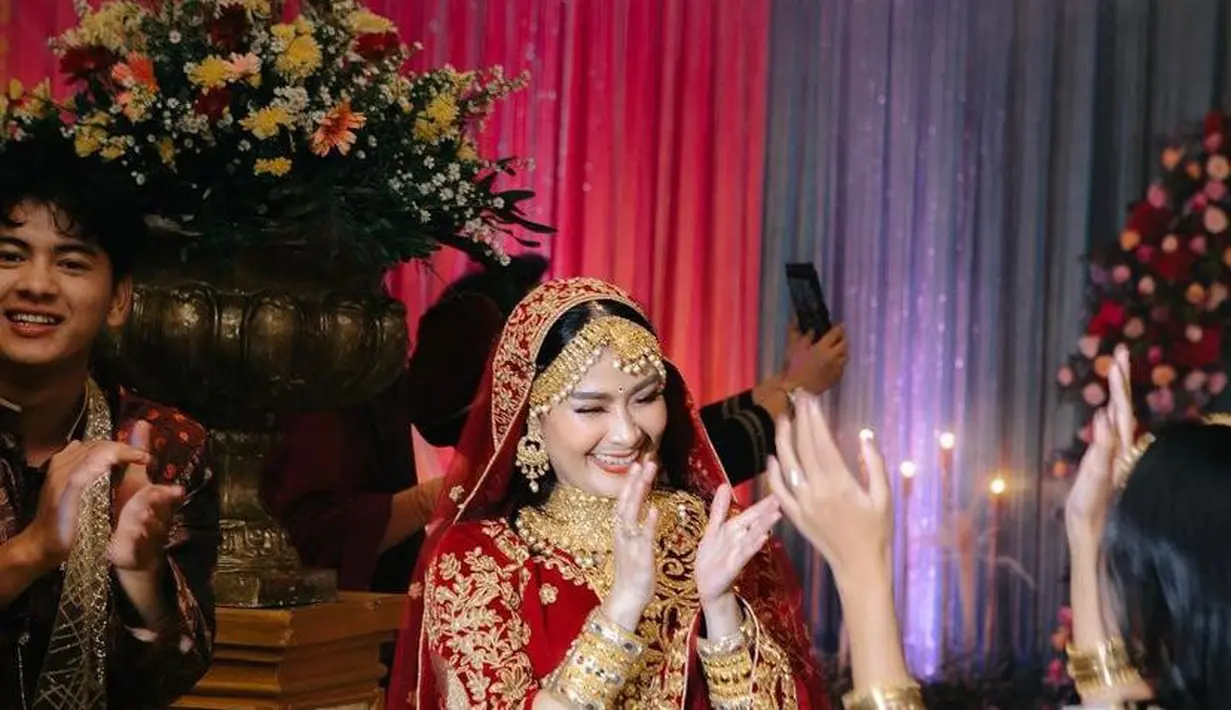 Untuk menyempurnakan penampilannya, Iis Dahlia juga mengenakan satu set aksesoris emas. Mulai dari hiasan kepala, kalung, hingga gelang. (Instagram/staar_studio).