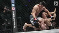 Dua petarung Indonesia Victorio Senduk (kiri) berusaha mengunci gerak Yohan Mulia Legowo (bawah) saat berlaga pada One Championship di Jakarta, Sabtu (20/1). Pada laga tersebut Victorio Senduk menang atas Yohan Mulia. (Liputan6.com/Faizal Fanani)