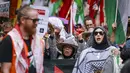Kematian tidak langsung tersebut disebabkan oleh penyakit, kondisi medis kronis yang tidak tertangani, serta dampak runtuhnya sistem layanan kesehatan akibat perang. Tampak dalam foto, para demonstran pro-Palestina membawa bendera, spanduk, dan plakat saat mereka berbaris berunjuk rasa di jalanan kota Sydney, Australia, Minggu 22 Februari 2026. (DAVID GRAY/AFP)