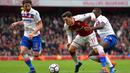 Gelandang Arsenal, Mesut Ozil, ditarik oleh bek Stoke Bruno Martins Indi, pada laga Premier league di Stadion Emirates, London, Minggu (1/4/2018). Arsenal menang 3-0 atas Stoke. (AFP/Oliver Greenwood)