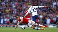 Gelandang Arsenal, Granit Xhaka, terjatuh saat berebut bola dengan gelandang Tottenham Hotspur, Christian Eriksen, pada laga Premier League 2019 di Stadion Emirates, Minggu (1/9). Kedua tim bermain imbang 2-2. (AP/Alastair Grant)