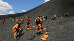 Antusias sejumlah wisatawan saat bersiap bermain sandboarding atau berseluncur pasir menuruni gunung berapi Cerro Negro di Leon, Nikaragua, 24 September 2016. Gunung Cerro Negro salah satu gunung api yang masih aktif di Nikaragua. (INTI Ocon/AFP)