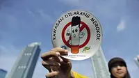 Seorang simpatisan menunjukkan stiker kawasan bebas merokok dalam aksi peringatan Hari Tanpa Tembakau di Bundaran Hotel Indonesia, Jakarta.(Antara)