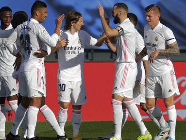Para pemain Real Madrid merayakan gol yang dicetak oleh Karim Benzema ke gawang Valencia pada laga Liga Spanyol di Stadion Alfredo Di Stefano, Minggu (14/2/2021). Real Madrid menang dengan skor 2-0. (AP/Manu Fernandez)