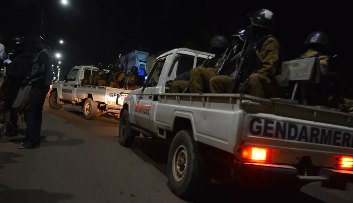 Sejumlah aparat kepolisian dan militer berpatroli setelah serangan oleh sekolompok orang bersenjata di sebuah kafe di Ouagadougou, Burkina Faso (13/8). Akibat kejadian tersebut sekitar 17 orang tewas dan 8 orang luka-luka. (AFP Photo/Ahmed Ouoba)
