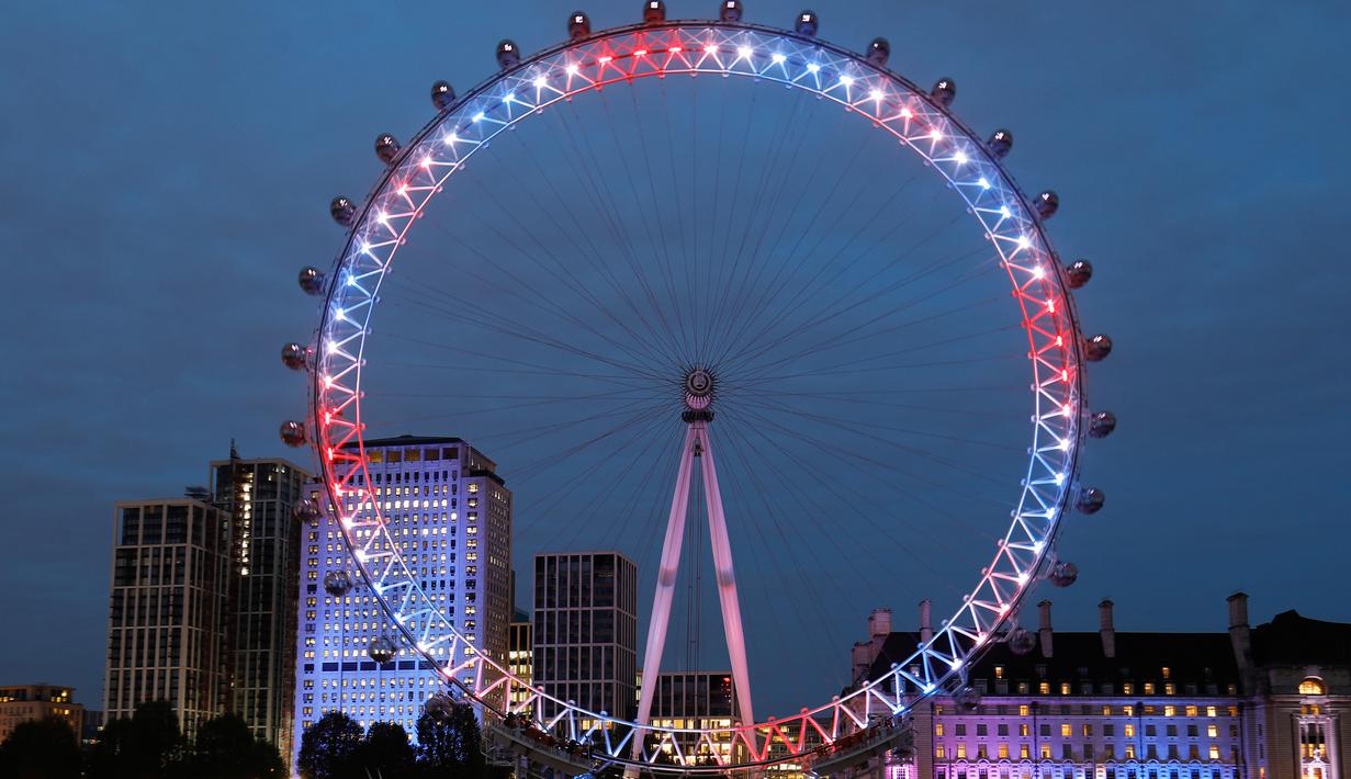 Eye menyalakan lampu berwarna merah, biru dan putih untuk menghormati kelahiran bayi laki-laki  Pangeran Harry dan Meghan Markle di London, Senin (6/5/2019). Bayi yang hingga kini belum diberi nama tersebut, lahir pada pukul 5:26 pagi waktu setempat dengan berat 3,2 kg. (Tolga AKMEN/AFP)