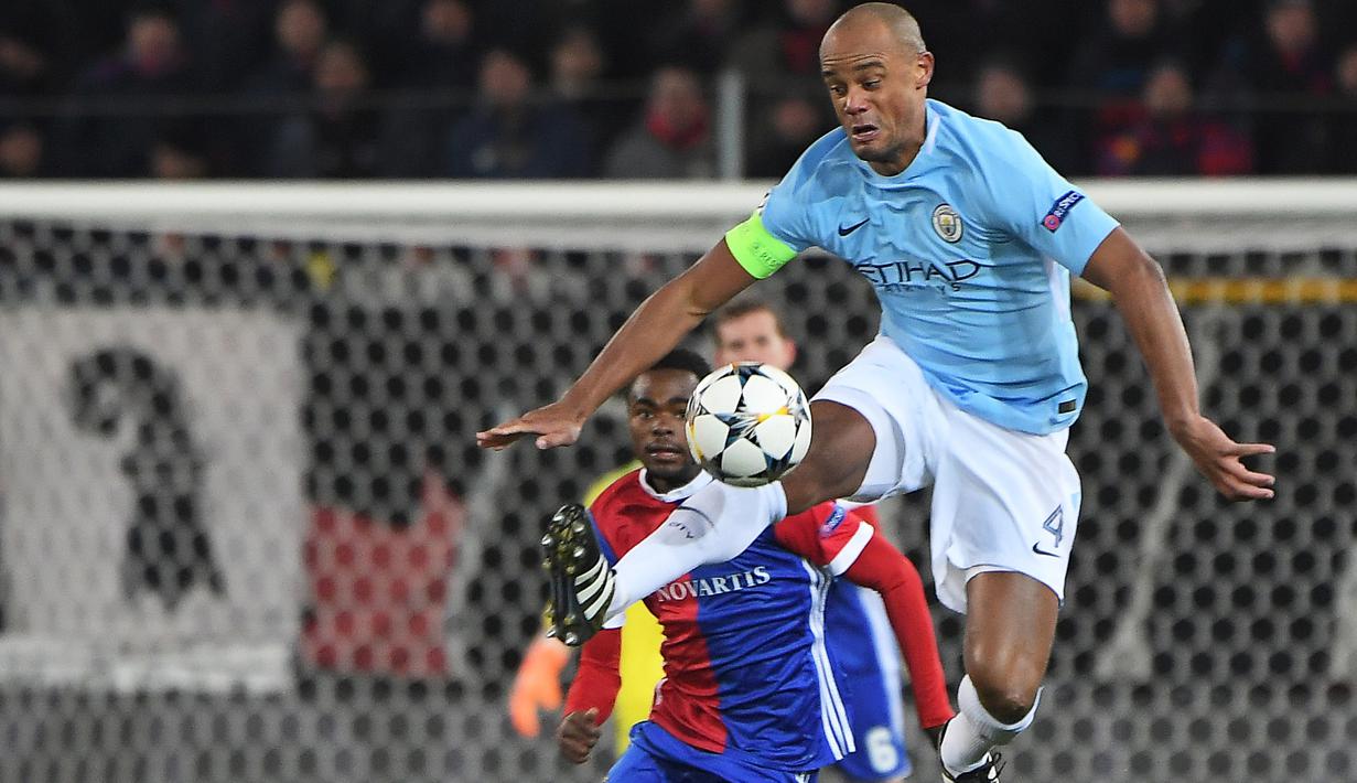 Aksi bek Manchester City, Vincent Kompany (kanan) menghalau bola dari kejaran pemain Basel, Dimitri Oberlin  pada laga 16 besar Liga Champions di Saint Jakob-Park Stadium, Basel, (13/2/2018). Manchester City menang 4-0. (AFP/Patrick Hertzog)