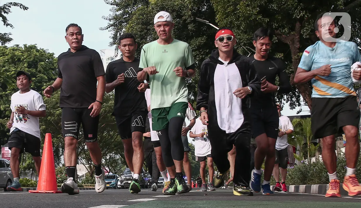 Calon presiden nomor urut 3 Ganjar Pranowo berlari pagi bersama masyarakat dalam acara Penguin SeliweRun di Senayan Park, Jakarta Pusat, Minggu (14/1/2024). (merdeka.com/ Arie Basuki)