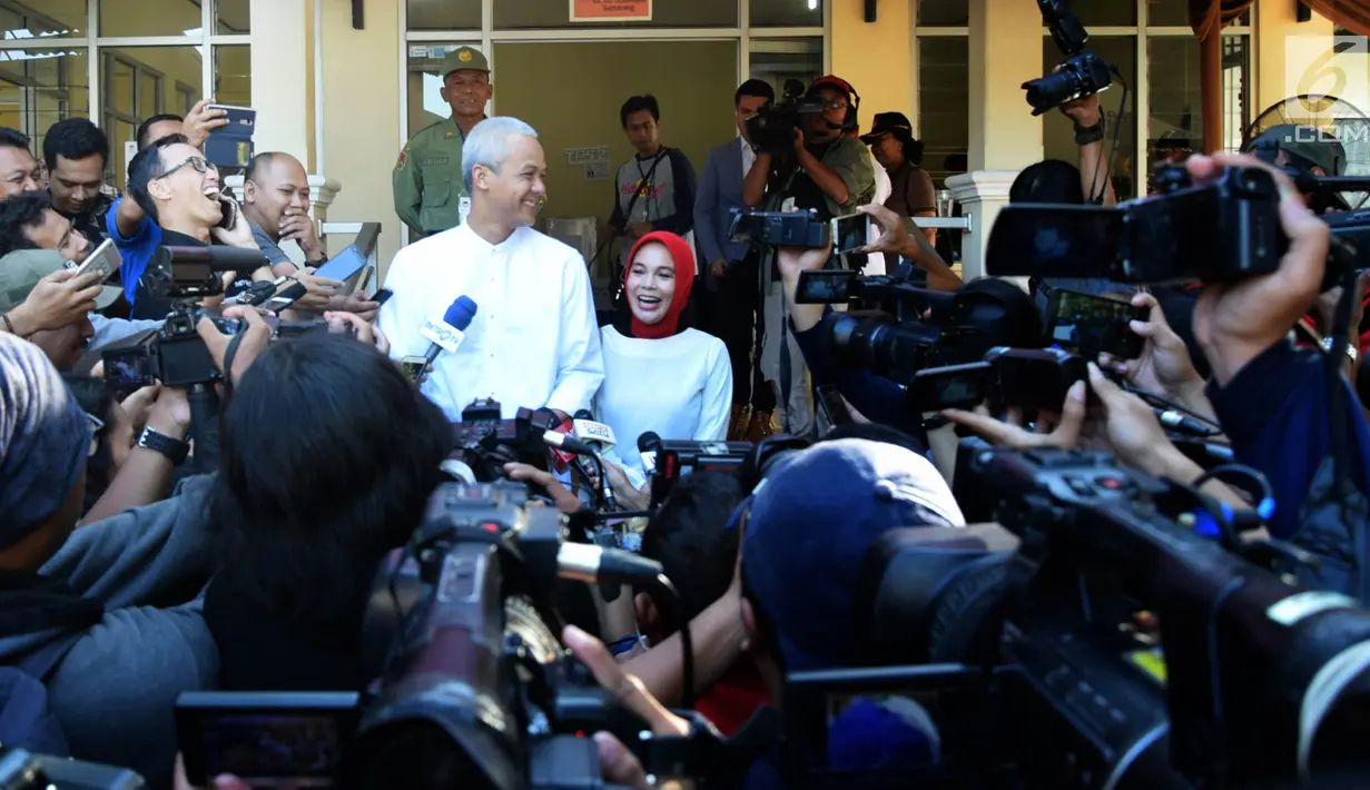 Calon Gubernur Jawa Tengah nomor urut 1, Ganjar Pranowo bersama istri, Siti Atiqoh seusai mencoblos pada pelaksanaan Pilkada Serentak 2018 di Tempat Pemungutan Suara ( TPS) 02 Kelurahan Gajahmungkur Kota Semarang, Rabu (27/6). (Liputan6.com/Gholib)