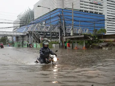 Pengendara motor menerobos banjir yang menggenangi Jalan Gunung Sahari, Pademangan, Jakarta Pusat, Selasa (21/2). Banjir setinggi pinggang orang dewasa menyebabkan terputusnya sejumlah akses jalan untuk kendaraan bermotor. (Liputan6.com/Faizal Fanani)