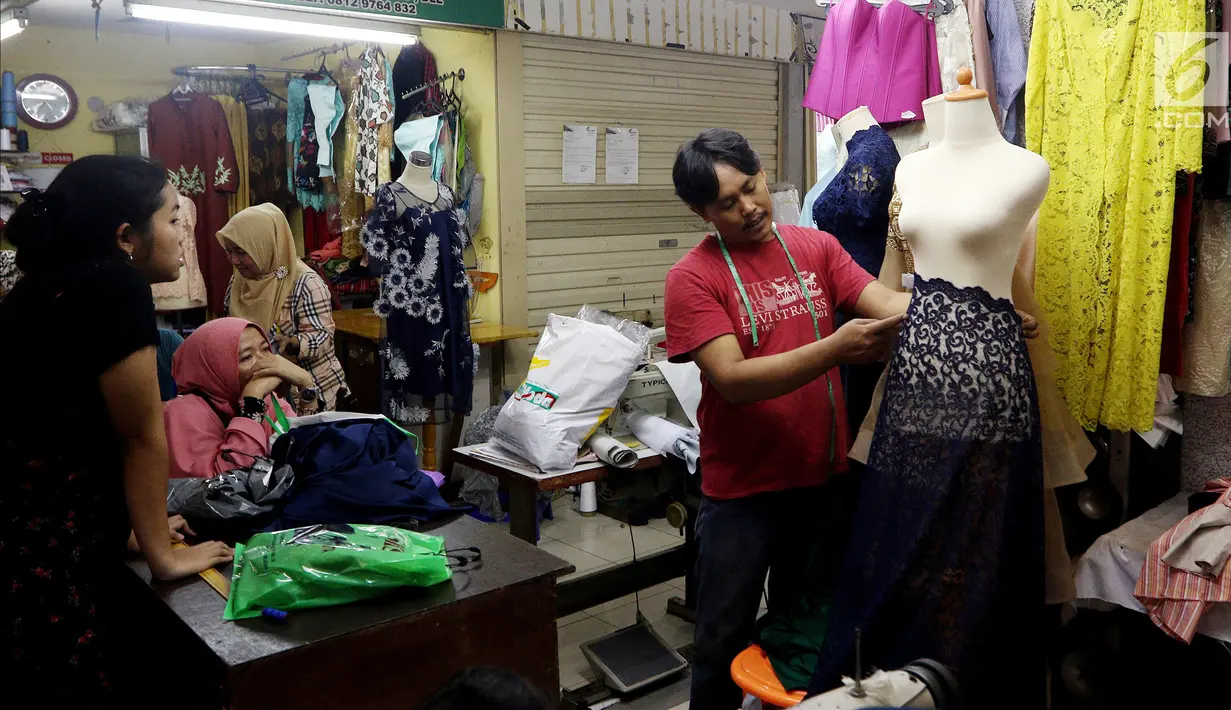 Seorang penjahit mengukur baju di Pasar Mayestik, Jakarta Selatan, Senin (11/6). Masyarakat mulai membeli dan membuat baju pilihan mereka jelang Lebaran. (Liputan6.com/JohanTallo)